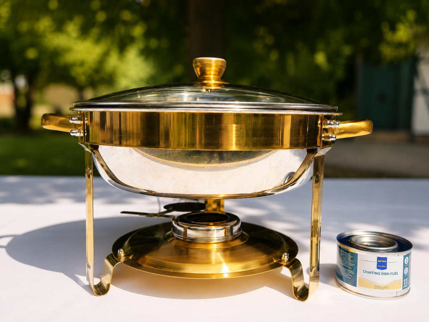 Runder Chafing Dish mit etwa 5 Litern Fassungsvermögen und Glasdeckel, daneben Beispiel Brennpaste