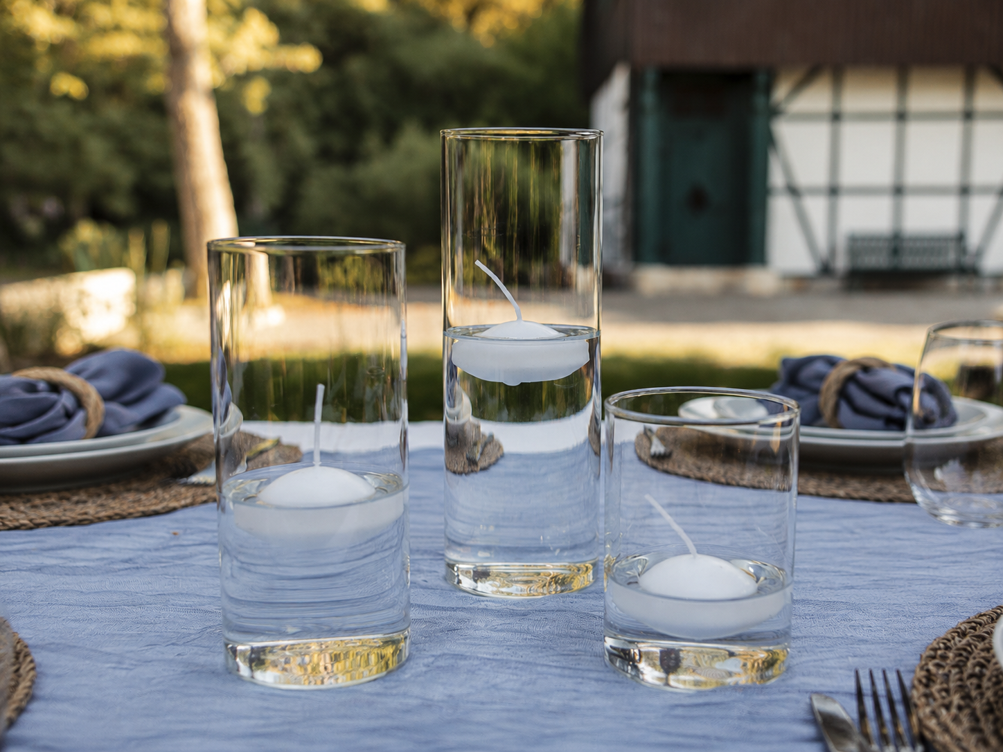 Festlich gedeckter Tisch mit Zylindergläsern und schwimmenden Kerzen