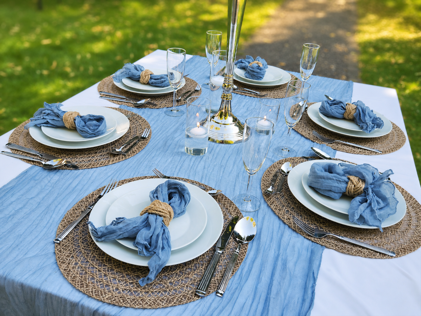 Festlich gedeckter Tisch mit weißen Tellern und blauen Servietten