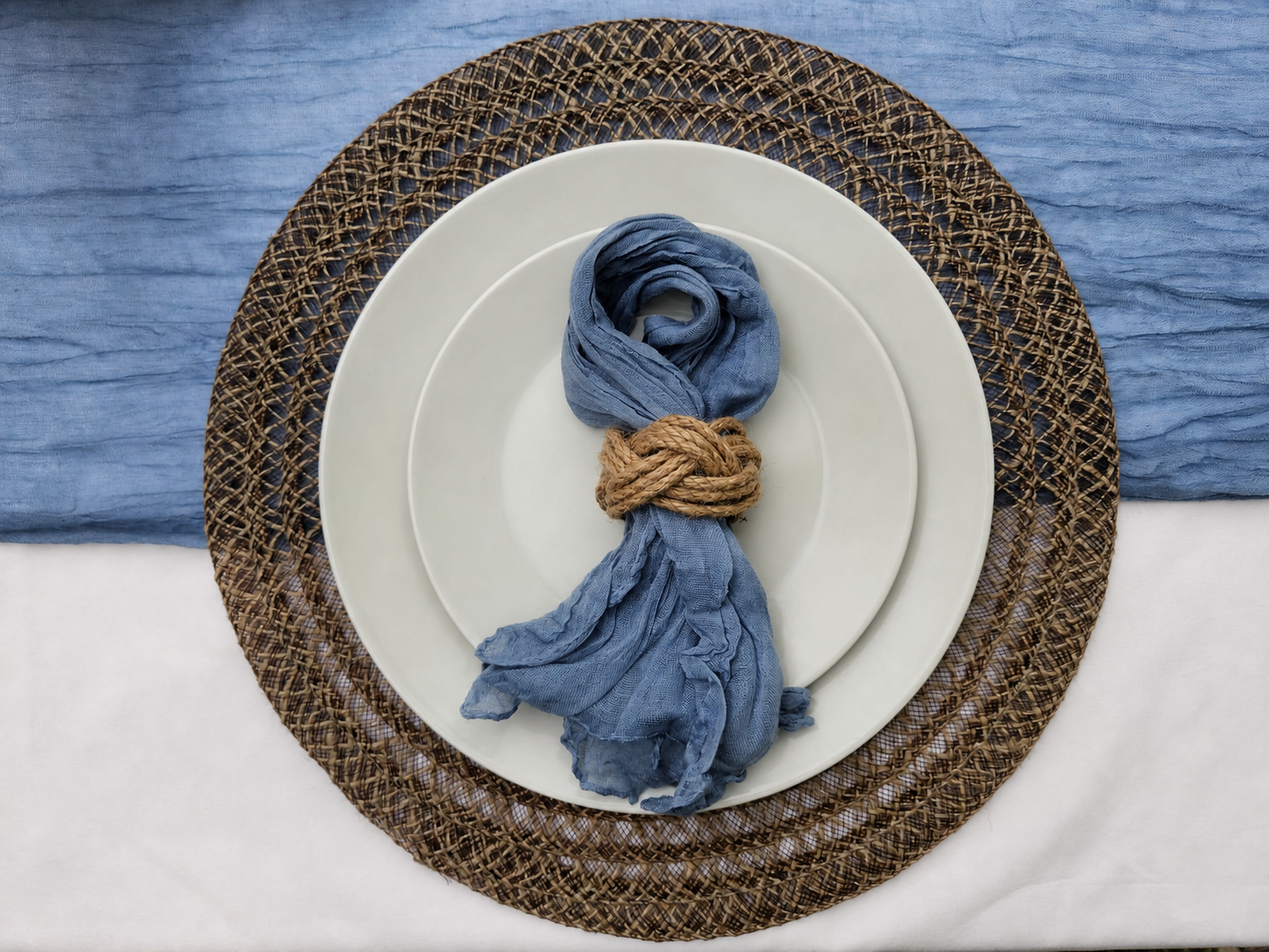 Weißes Tellerset mit Speise- und Dessertteller auf natürlichem Platzset mit Serviette